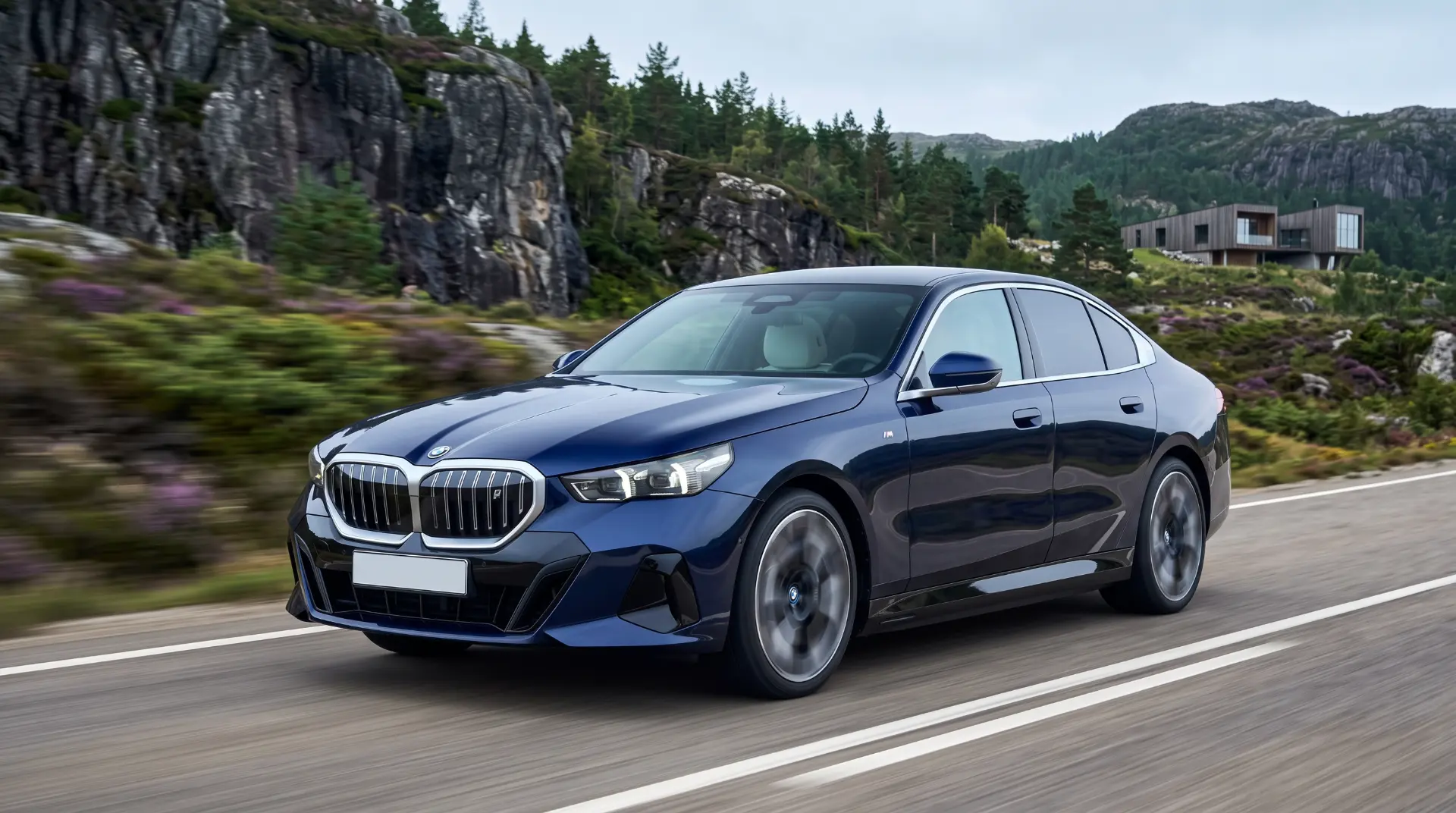 Blå BMW i5 på en vej mellem fjelde